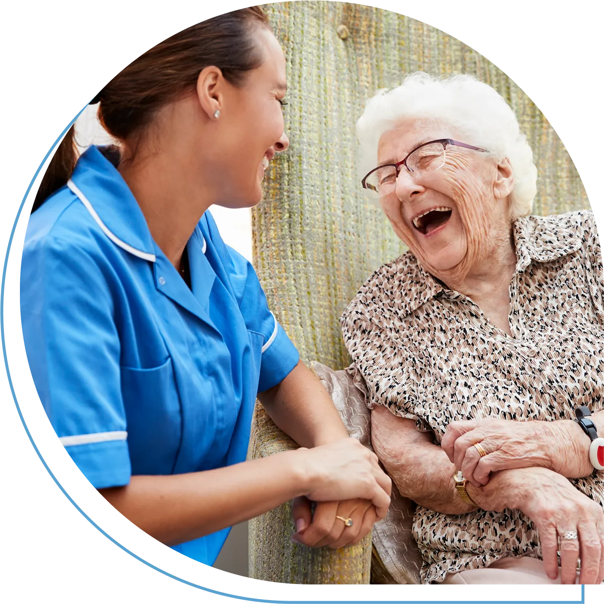 Nurse laughing with elderly woman outside.