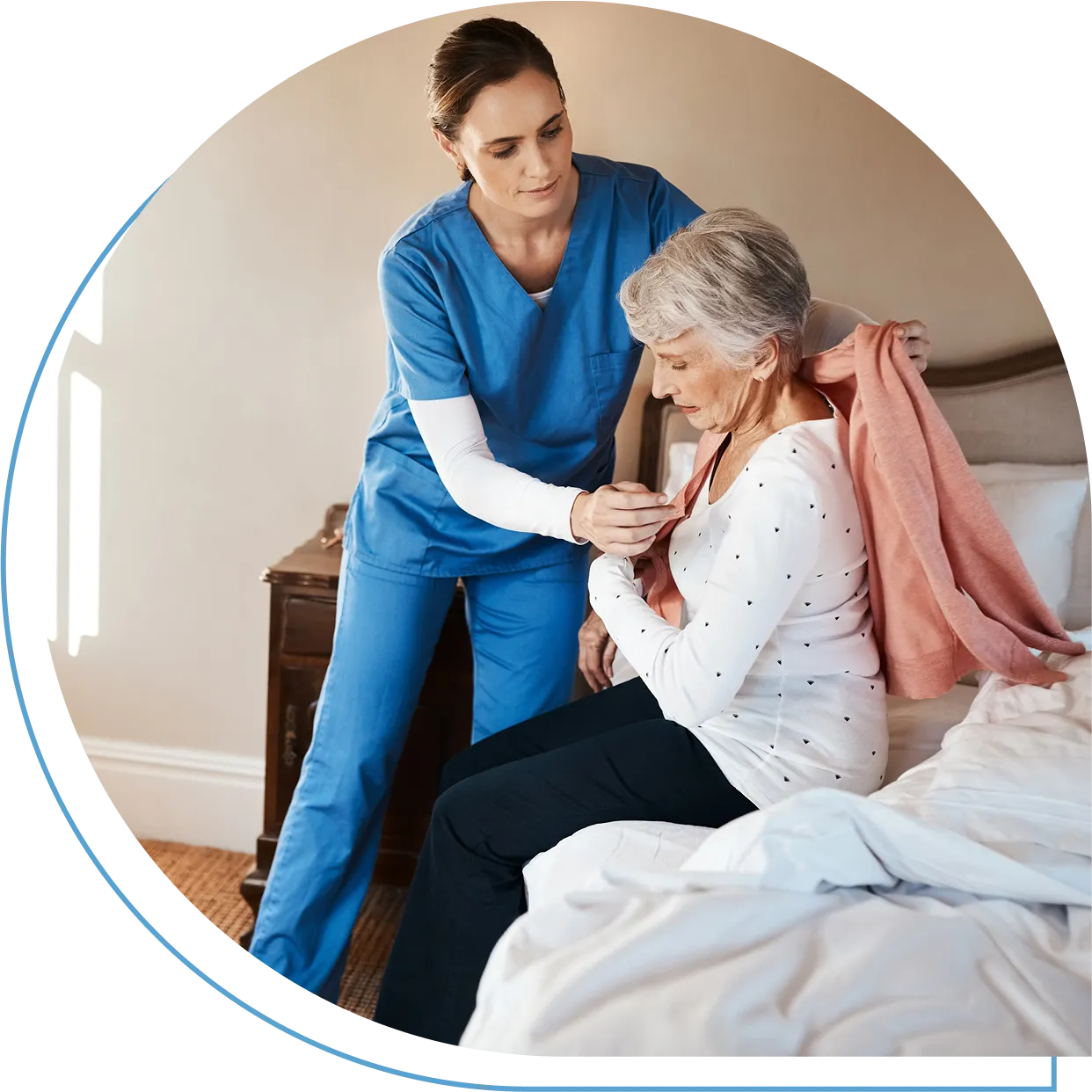 Caregiver assisting elderly woman with clothing.